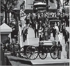  ?? SUSAN WALSH/AP ?? Family members follow a horse-drawn caisson that carries the casket of Sen. John McCain, R-Ariz., as it proceeds to the United States Naval Academy cemetery.