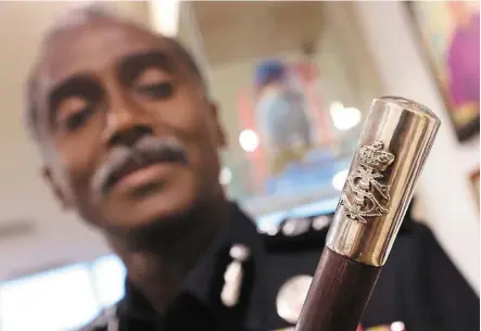  ?? — thomas yong/the Star ?? comm Kumar showing a special customised baton with the royal emblem from Sultan Ibrahim after he took over as the state top cop.