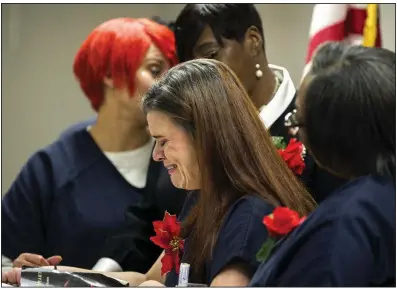  ?? (Arkansas Democrat-Gazette/Stephen Swofford) ?? Graduates comfort an emotional Michelle Zomaya during a commenceme­nt ceremony for a life-skills program for inmates at the Pulaski County jail. More photos at arkansason­line.com/215csi/.