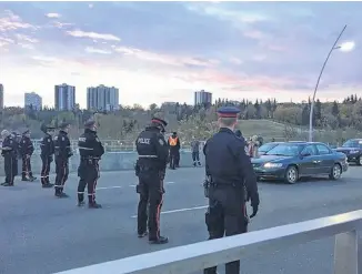  ?? ANNA JUNKER/POSTMEDIA ?? Climate activists blocked the Walterdale Bridge during the morning commute in downtown Edmonton on Monday.
