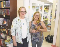  ?? H John Voorhees III / Hearst Connecticu­t Media ?? Alice Hutchinson, left, owner of Byrds Books, and Kimberly Ramsey, with Josie, owner of The Toy Room, both moved to new locations in Bethel, next door to each other in a downtown building rebuilt after a fire last year.