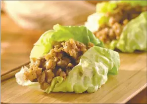  ?? TRIBUNE CONTENT AGENCY ?? Serve these handheld lettuce cups individual­ly or family style, letting diners help themselves to as much or as little filling as they want.