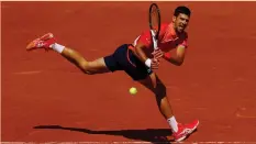  ?? (Reuters) ?? SERBIA’S NOVAK DJOKOVIC returns a shot during his straight-set first-round victory over American Aleksandar Kovacevic yesterday at Roland Garros.