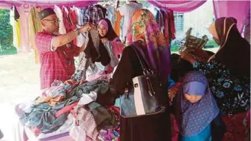  ??  ?? GOLONGAN kurang berkemampu­an memilih pakaian yang disumbangk­an orang ramai di Rumah Mahabbah Kota Bharu di Jalan Guchil Bayam.