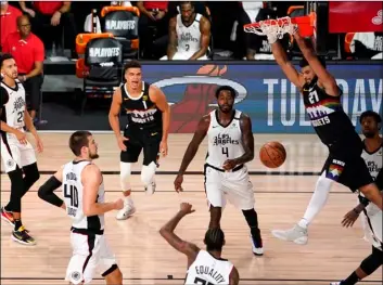  ?? AP Photo/Mark J. Terrill ?? Denver Nuggets’ Jamal Murray (27) hangs on the rim after dunking the ball against the Los Angeles Clippers during the second half of an NBA conference semifinal playoff basketball game on Sunday, Sept. 13, 2020, in Lake Buena Vista, Fla. The Nuggets won 111-98.