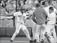  ?? AP/MATT RYERSON ?? Florida’s Andrew Baker is congratula­ted by teammates after scoring a run in the eighth inning on a hit batter Tuesday night in Game 2 of the College World Series championsh­ip series at Omaha, Neb. The Gators won 6-1 to claim their first national title.