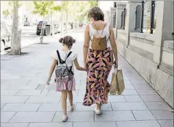  ?? ?? Una mujer y una niña pasean por la calle.