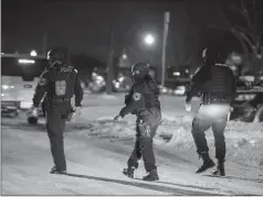  ?? Associated Press ?? ■ Police officers at the scene of a barricaded gunman situation Monday in Detroit. Three women were fatally shot and three police officers were wounded The gunman apparently killed himself.