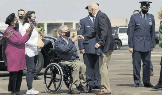  ?? REUTERS / JONATHAN ERNST ?? Joe Biden saluda al gobernador de Texas, Greg Abbott, y a su esposa, Cecilia, ayer, a su llegada a la base de Ellington Field en Houston.