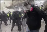  ?? JOHN MINCHILLO — THE ASSOCIATED PRESS ?? Trump supporters try to break through a police barrier on Wednesday at the Capitol in Washington.