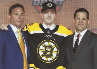  ?? GETTY IMAGE ?? NEW GUY: Defenseman Urho Vaakanaine­n (center) poses with coach Bruce Cassidy (left) and general manager Don Sweeney after being selected 18th overall in last night’s NHL draft in Chicago.