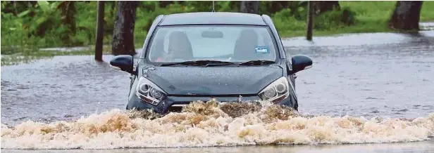  ?? ?? SEBUAH kereta Perodua Axia sedang mengharung­i air banjir di Jalan Kong Yit Khim sepanjang kira-kira 38 kilometer yang terletak di tepi Sungai Rajang petang kelmarin. Jalan terbabit merupakan kawasan yang sering terdedah dengan banjir yang juga jalan pintas ke Lebuh Raya Pan Borneo di Jambatan Durin.