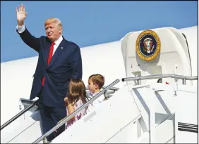  ?? AP PHOTO ?? In this Aug. 4 photo, President Donald Trump waves as he walks down the steps of Air Force One with his grandchild­ren, Arabella Kushner, centre, and Joseph Kushner, right, after arriving at Morristown Municipal Airport in Morristown, N.J.