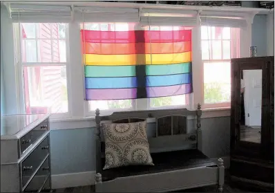  ?? Special to the Democrat-Gazette/KIM DISHONGH ?? A Pride flag hangs in a window of the Pink House, with the sun lighting up its rainbow of colors.