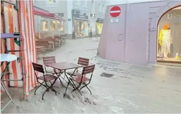  ?? /Reuters ?? Town torrent: Floodwater runs down the Old Town of Berchtesga­den amid heavy rainfalls in Bavaria, in Germany, on Saturday that left one person dead. More than 180 people have died in Europe in the past few days amid widespread flooding.