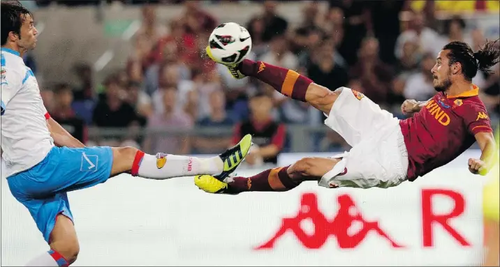  ?? — REUTERS ?? AS Roma’s Pablo Osvaldo, right, takes a shot as Catania’s Nicola Legrottagl­ie tries to block him during their Serie A match at the Olympic stadium Sunday in Rome.