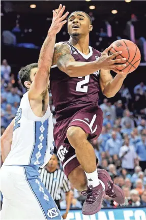  ?? BOB DONNAN/USA TODAY SPORTS ?? Texas A&amp;M guard TJ Starks drives against Luke Maye en route to scoring 21 points in the Aggies’ upset victory Sunday.
