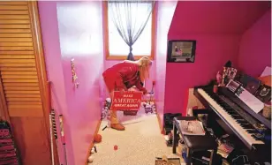  ??  ?? LEWISTON: Trump supporter Stephanie Rodrigue, 17, picks up one of the campaign signs she’s collected in her room. — AP photos