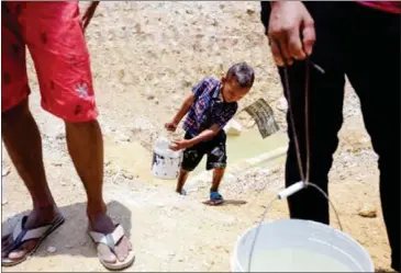  ?? HONG MENEA ?? A child carries water from a pool in Banteay Meanchey province last year after drought conditions in Cambodia caused widespread water shortages.