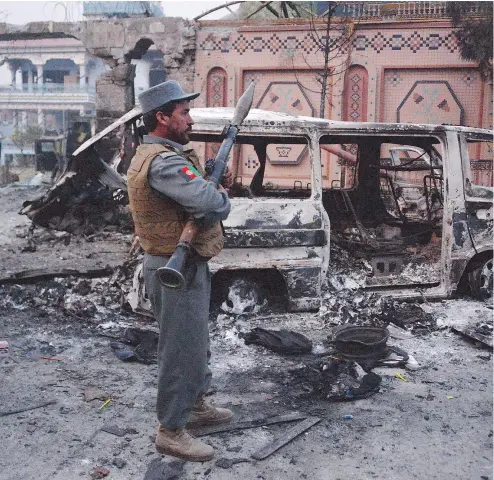  ?? NOORULLAH SHIRZADA / AFP / GETTY IMAGES ?? Afghan security forces inspect the site of an attack on the Save the Children office in Jalalabad on Wednesday.