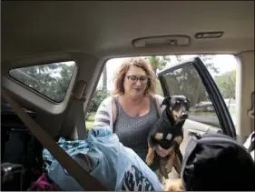  ??  ?? Julie Logsdon loads her dogs Tobias and Luna into her car in Panama City, Fla., as Hurricane Michael approaches on Tuesday. JOSHUA BOUCHER/NEWS HERALD VIA AP