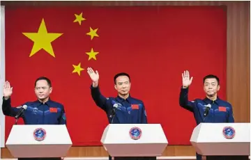  ?? — ?? Ready for lift-off:
Chinese astronauts on the shenzhou-15 mission (from left) Zhang Lu, Fei Junlong and deng Qingming waving during a meeting with the press at the Jiuquan satellite Launch Center in northwest China.
Xinhua