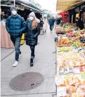  ?? JOE KLAMAR/GETTY-AFP ?? People walk through a market Friday in Vienna that will close next week under a lockdown order.