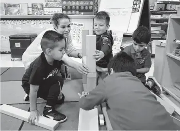  ?? Kin Man Hui/staff file photo ?? Dual language prekinderg­arten teacher Vanessa Guerra engages with her students playing with building blocks at Menchaca Early Childhood Center in Southside ISD in September.