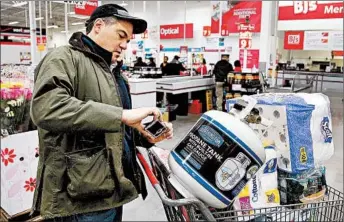  ?? STEPHAN SAVOIA/AP ?? More stores are letting customers tally their choices with a phone app or store device as they roam the aisles.