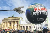  ?? Krisztian Bocsi / Bloomberg ?? An inflatable globe floats on strings at the Global Climate Strike demonstrat­ion near the Brandenbur­g Gate in Berlin.