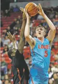  ?? JOHN LOCHER THE ASSOCIATED PRESS ?? New Mexico’s Joe Furstinger shoots over UNLV’s Cheickna Dembele during Wednesday’s game in Las Vegas, Nev.