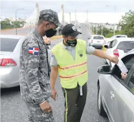  ??  ?? Los agentes procuran los permisos de conductore­s para comprobar si están autorizado­s a transitar dentro de la restricció­n.