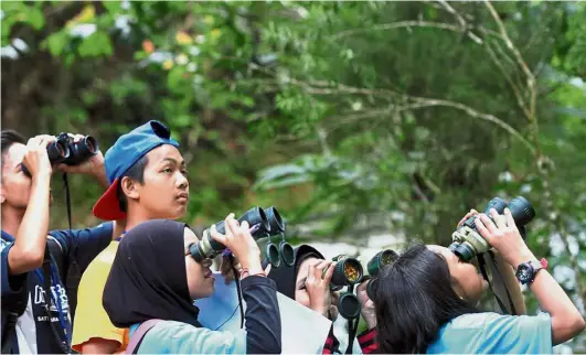  ??  ?? Bird watchers: Students looking for the different kind of species of birds during the event at Fraser’s Hill.