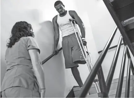  ??  ?? July 26, 2018 - Jabari Bailey, right, practices descending stairs on his own while doing physical therapy with Audrey Pinner, a physical therapist at Regional One Health. BRAD VEST/THE COMMERCIAL APPEAL