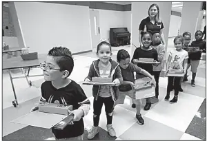  ??  ?? AP/JOHN RAOUX Puerto Rican pupils head to their classrooms Tuesday after they were given school supplies and books at Riverdale Elementary School in Orlando, Fla.