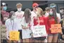  ?? OWEN MCCUE - MEDIANEWS GROUP ?? Chester County athletes hold up their signs during a rally outside the Chester County Department of Health on Monday in West Chester.