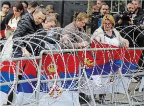  ?? BOJAN SLAVKOVIC THE ASSOCIATED PRESS ?? Protesters attach Serbian flags to a fence in front of the city hall in the town of Zvecan, northern Kosovo on Wednesday. Hundreds repeated efforts to take over the offices where ethnic Albanian mayors took up their posts last week.