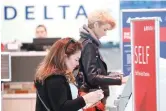  ?? AP Photo/LM Otero, file ?? ■ Travelers use the Delta airlines self check-in at Love Field in Dallas, Nov. 27, 2019. Delta Air Lines will be able to continue operating flights at Dallas Love Field for another six years, under a settlement approved by the city council. The agreement, which passed without debate this week, appears to end a long court fight over gates at the city-owned airport near downtown Dallas that is dominated by Southwest Airlines.