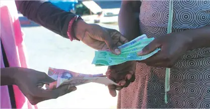  ??  ?? Illegal currency dealers transact in Harare recently