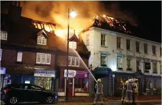  ?? ?? Inferno: The hotel, right, was one of several buildings engulfed in flames