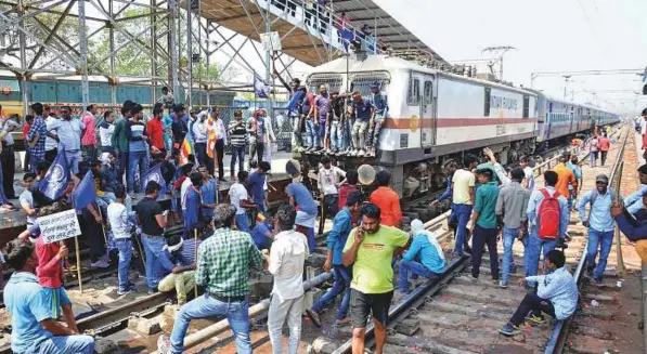  ?? AFP ?? Protesters block a train at a station during a countrywid­e strike against the Supreme Court order in Mathura in Uttar Pradesh yesterday. Maintainin­g that the SC/ ST Act was being misused by Dalits in certain cases, the court last week stopped the...