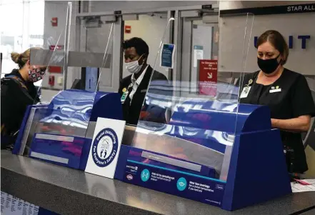  ?? Yi-chin Lee / Staff photograph­er ?? United Airlines customer-service representa­tives help passengers at the boarding gate at Houston’s George Bush Interconti­nental Airport. Flight attendants suggest arriving an hour or two earlier than normal.