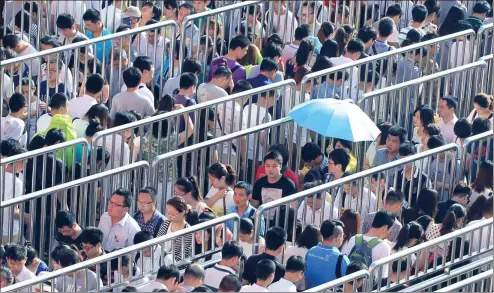  ?? ZHU XINGXIN / CHINA DAILY ?? Commuters line up to enter the Tiantongyu­an North Subway Station in Beijing at about 7:30 am. Located between the Fifth and Sixth Ring Roads, the station is crowded during the morning rush hour as local residents head to work downtown.