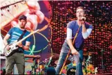  ??  ?? Lead singer of British band Coldplay Chris Martin (right) with guitarist Jonny Buckland perform at The Stade de France Arena in Saint Denis.