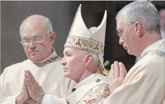  ?? NATI HARNIK THE ASSOCIATED PRESS ?? Omaha Archbishop George Lucas, centre, said in a written statement, “We’re deeply saddened so many innocent minors and young adults were harmed by the church’s ministers.”