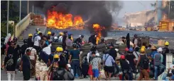  ?? REUTERS STRINGER ?? ANTI-coup protesters stand at a barricade as they clash with security forces on Bayint Naung Bridge in Mayangone, Yangon, Myanmar. |