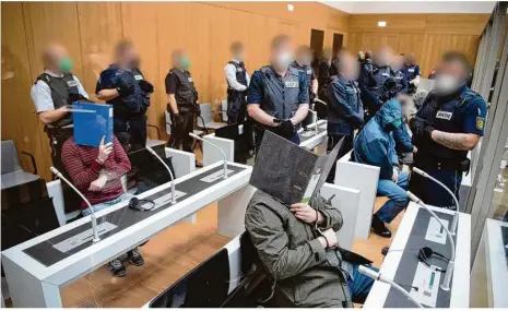  ?? Foto: -/dpa-pool/dpa ?? Im Beisein von Justizbeam­ten warten Angeklagte der rechten Vereinigun­g „Gruppe S.“auf den Prozessbeg­inn.