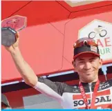  ??  ?? HATTA: Caleb Ewan of Lotto-Soudal cycling team waves as he poses holding the stage winner trophy after winning the second stage of the UAE Cycling Tour from Hatta to Hatta Dam yesterday. — AFP