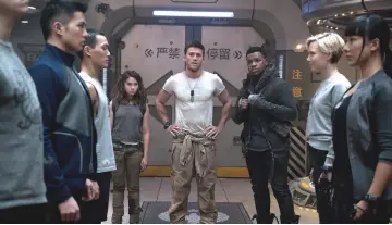  ??  ?? At centre, from left to right, Spaeny, Scott Eastwood and Boyega star in ‘Pacific Rim: Uprising’. (Below) Giant robots, known as Jaegers, must defend the world from monsters from another dimension in the film. — Courtesy of Universal Pictures