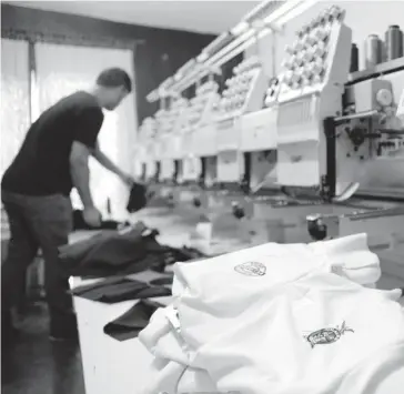  ?? FOTO: RICARDO NEVAREZ ?? > Trabajador de un comercio realizando confección de uniformes.